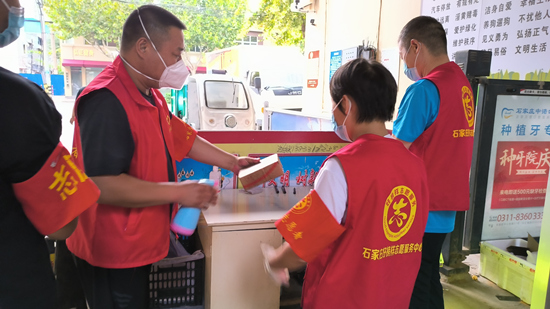 志愿者在社区门口接送快递。石家庄市文明办供图